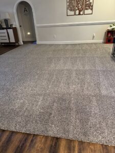 A large room with a freshly installed or professionally cleaned grey carpet by Drew's Cleaning and Restoration in Jamestown, NC.