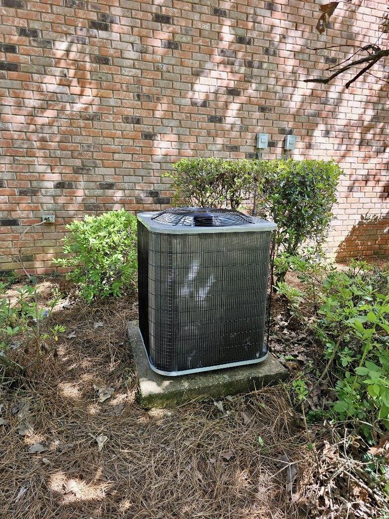 A newly installed outdoor AC unit next to a brick wall, completed by Faith Heat and Cool in West Monroe, LA