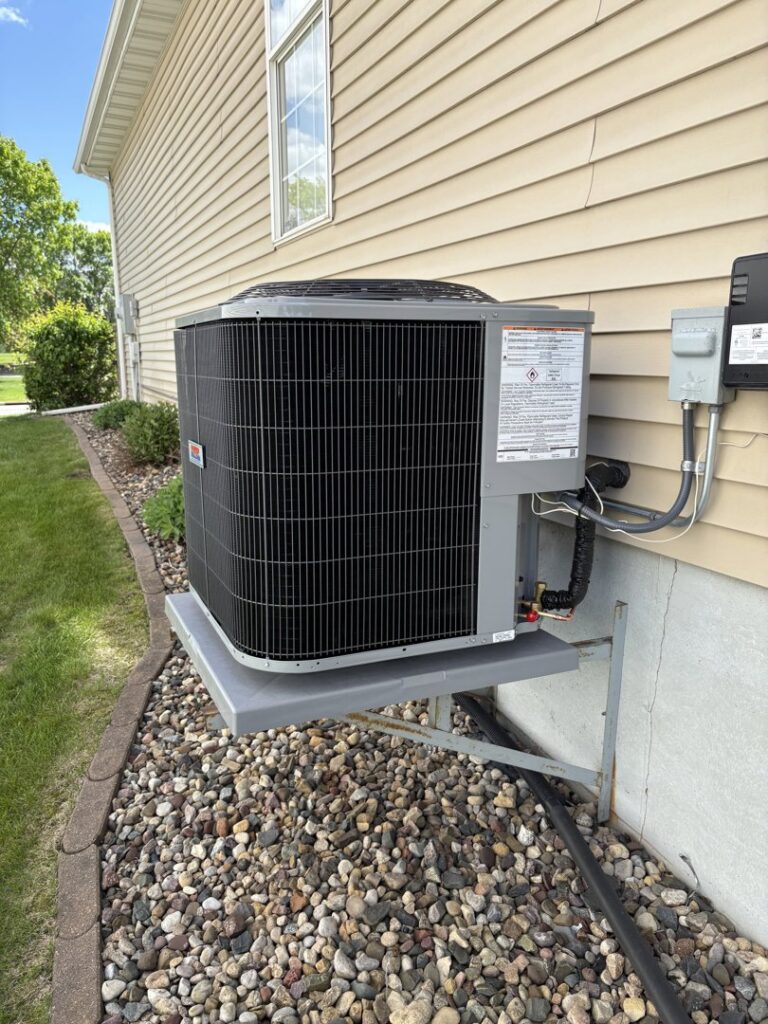 A newly installed or recently serviced outdoor air conditioning unit next to a home by Holzer Heating And Cooling in Savage, MN