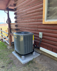 A newly installed outdoor HVAC condenser unit next to a home by Ryan's Heating & Air in Kalispell, MT.
