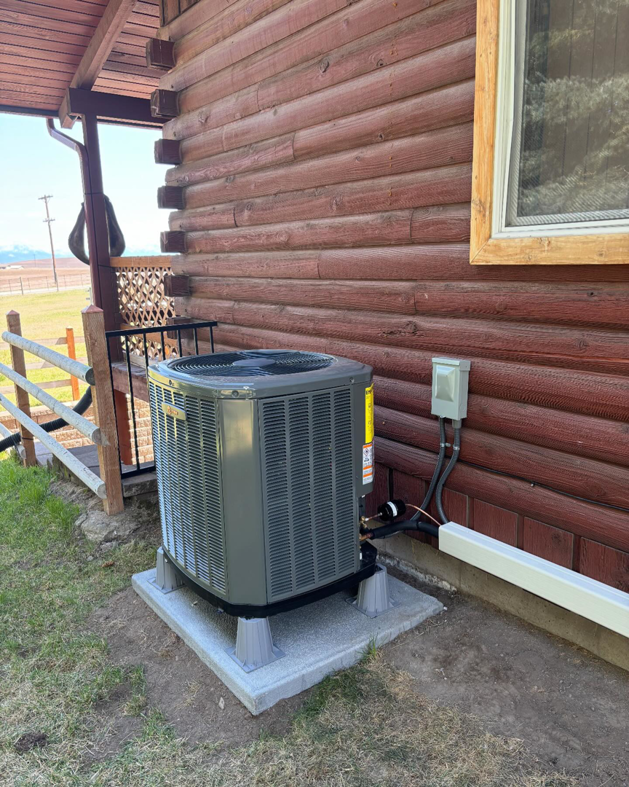 A newly installed outdoor HVAC condenser unit next to a home by Ryan's Heating & Air in Kalispell, MT.