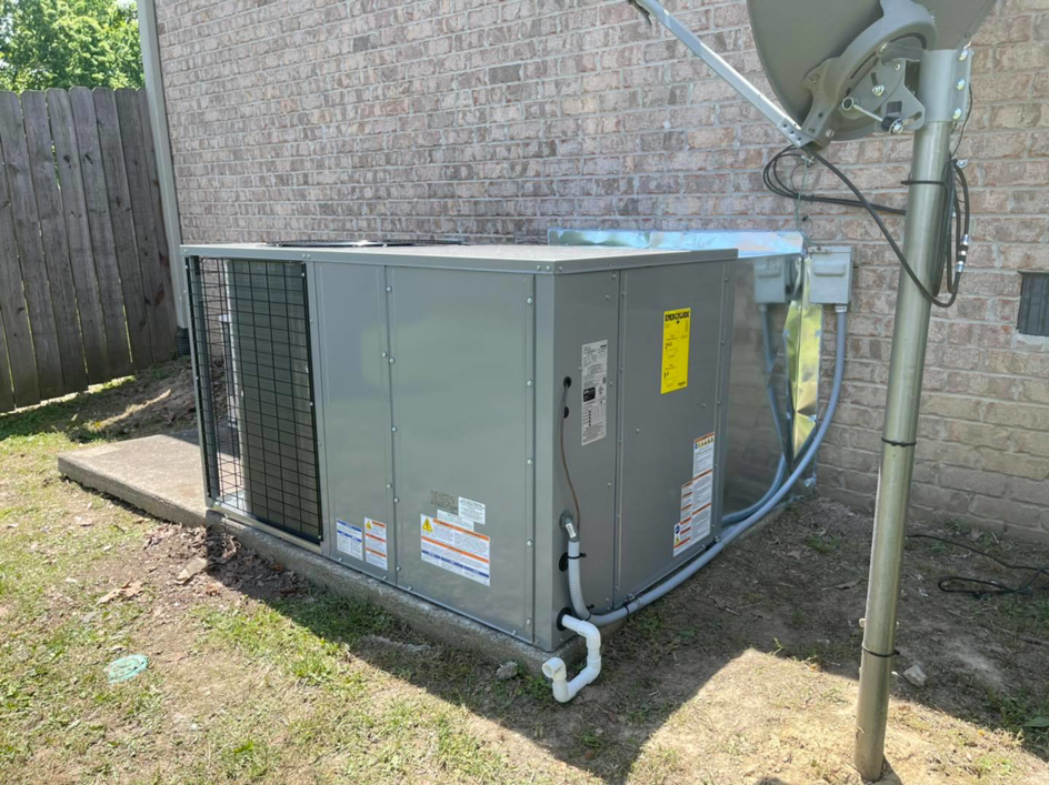 A newly installed outdoor HVAC system with ductwork connections next to a brick house by Wright Air Care in Murfreesboro, TN.