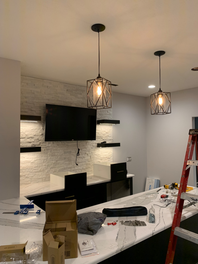 Newly installed pendant lights and recessed lighting in a modern room by Crown Enterprises Electrical Contracting in Omaha, NE.