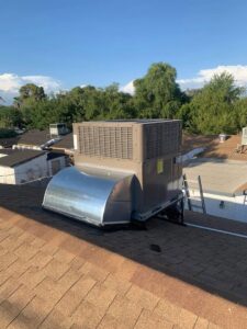 A newly installed rooftop HVAC unit with connected ductwork on a residential roof by BH cooling & Heating in Glendale, AZ.