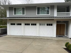 Newly installed white carriage-style garage doors on a modern home by AAA Garage Door Services in Renton, WA