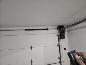 An inside view of a newly installed white paneled garage door with visible tracks and springs by Alliance Overhead Garage Doors Inc. in Portland, OR.