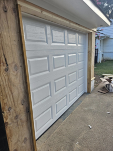 A newly installed white garage door with wooden framing by The Garage Man in Memphis, TN.