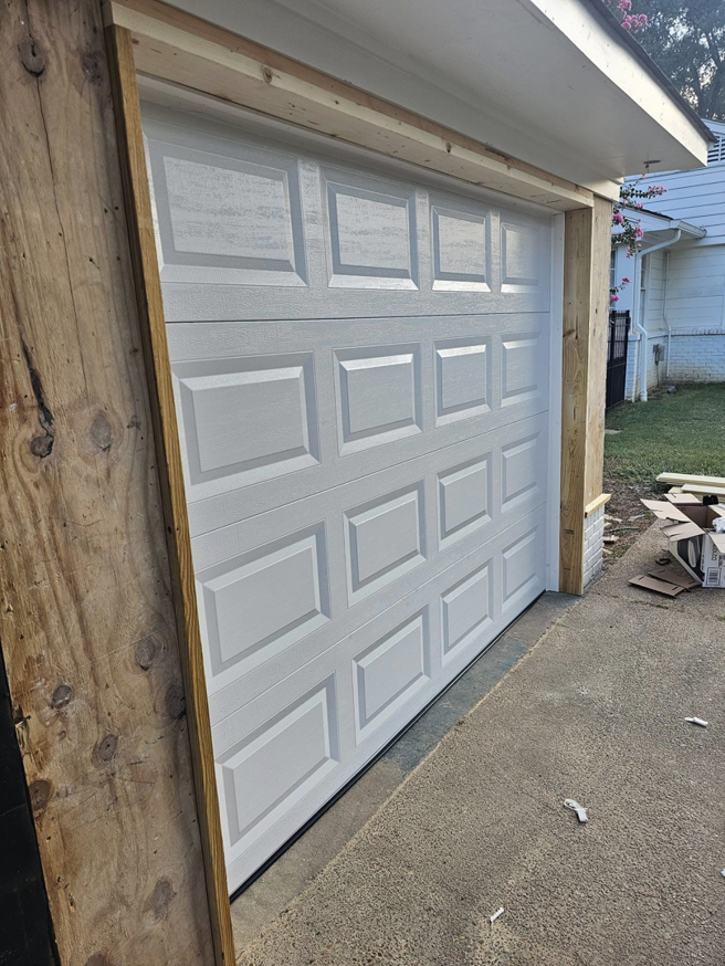 A newly installed white garage door with wooden framing by The Garage Man in Memphis, TN.