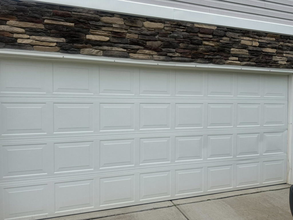 A newly installed white panel garage door on a residential home by 2BroGarage LLC in Charlotte, NC.