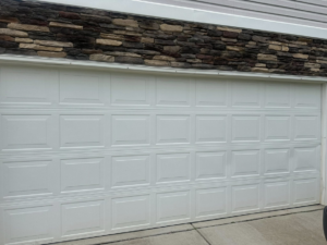 A newly installed white panel garage door on a residential home by 2BroGarage LLC in Charlotte, NC.