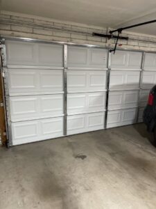 A newly installed white panel garage door inside a residential garage by Az Garage Door in Phoenix, AZ.