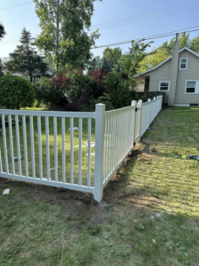 A newly installed white picket-style fence in a residential backyard by T & A Fencing in Warren, MI.