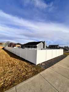 A newly installed white vinyl privacy fence surrounding a residential property by BKC Fencing in Spokane, WA.