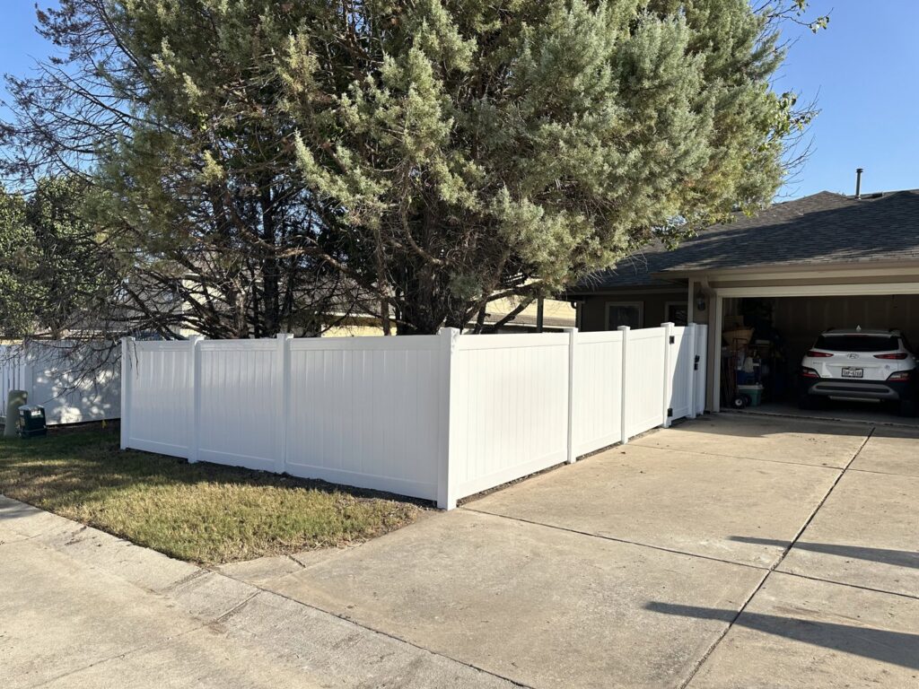 A newly installed white vinyl privacy fence providing a clean look for a home by Stand Strong Fencing of East Austin, TX.