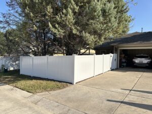 A newly installed white vinyl privacy fence providing a clean look for a home by Stand Strong Fencing of East Austin, TX.