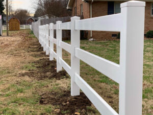 A newly installed white vinyl ranch-style fence, offering a classic look by Stand Strong Fencing of East Austin, TX.
