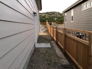 A newly installed wooden privacy fence running along a residential property by ER Fencing LLC in Denver, CO.