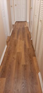 A hallway featuring newly installed wood-look flooring by Carpet Warehouse in Lafayette, IN.