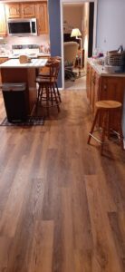 A bright kitchen featuring newly installed wood-look flooring by Carpet Warehouse in Lafayette, IN.