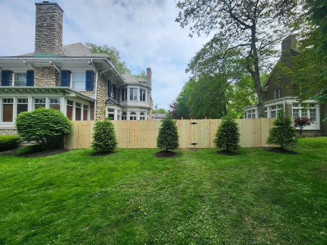 A newly installed wood privacy fence separating two large residential properties by City Fence Inc. in Lancaster, NY.
