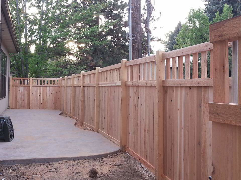A newly installed wood privacy fence with a decorative top section by Double A Fence LLC in Boise, ID.