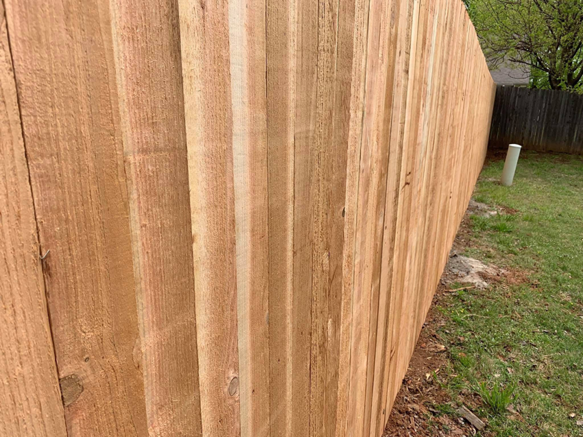 A newly installed wood privacy fence, showcasing quality craftsmanship by Fence Innovations in Norman, OK.