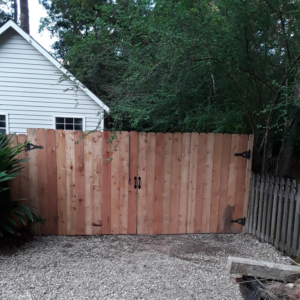 A newly installed wood privacy fence with a double gate, showcasing quality work by Country Boyz fencing in Biloxi, MS.