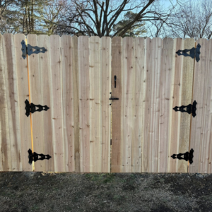 A newly installed wood privacy fence gate with black decorative hardware by McDaniel Quality Fencing LLC in Muldrow, OK.