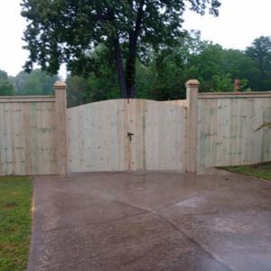 A newly installed wooden privacy fence with a double gate across a driveway by Southwest Fence Company Inc in Weatherford, OK.