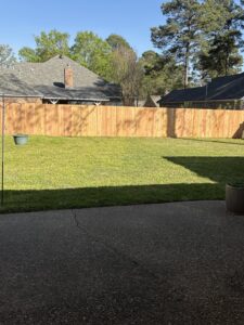 A newly installed wood privacy fence enclosing a residential backyard by Lynch's Lawn & Fence LLC in Bossier City, LA.