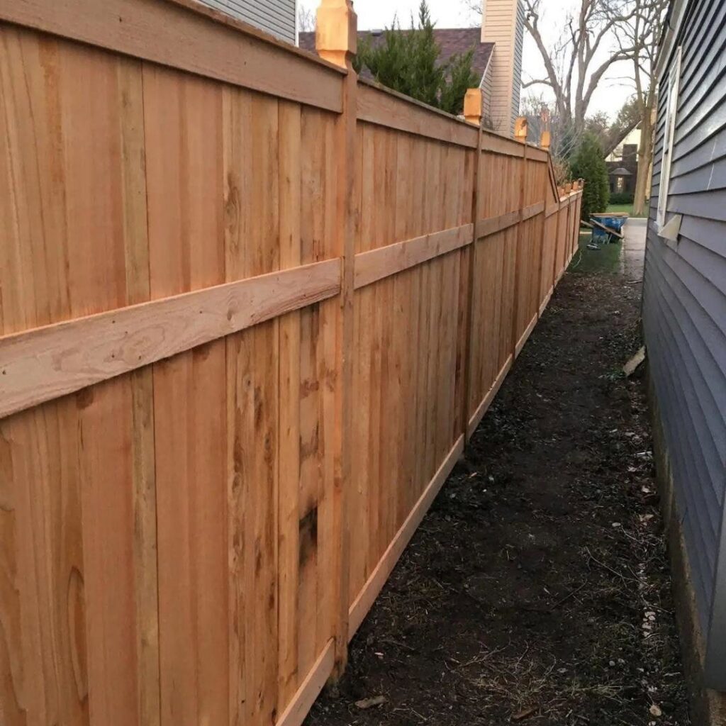 A newly installed natural wood privacy fence by Midwest Legacy Fence & Deck in Aurora, IL, separating a residential property.