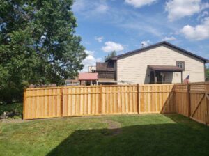 A newly installed wood privacy fence in a residential backyard by MN Mike's Fence and Repair in Lakeville, MN.