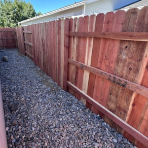 A newly installed wooden privacy fence along a gravel path by Mule Fence Inc. in Sparks, NV.