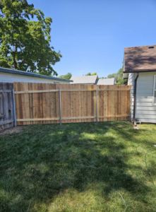 A newly installed wood privacy fence in a residential backyard by Regan Fencing & Services in Nampa, ID.