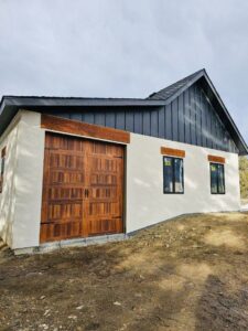 A residential house featuring a newly installed wooden panel garage door by PNG Garage Doors llc in Lakewood, CO.