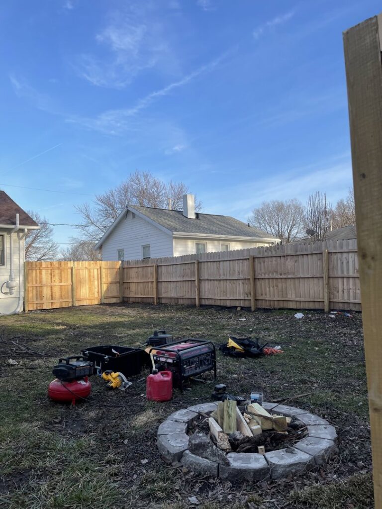 A newly installed wooden privacy fence in a residential backyard, showcasing work by Stallworth Home Improvement in Des Moines, IA.