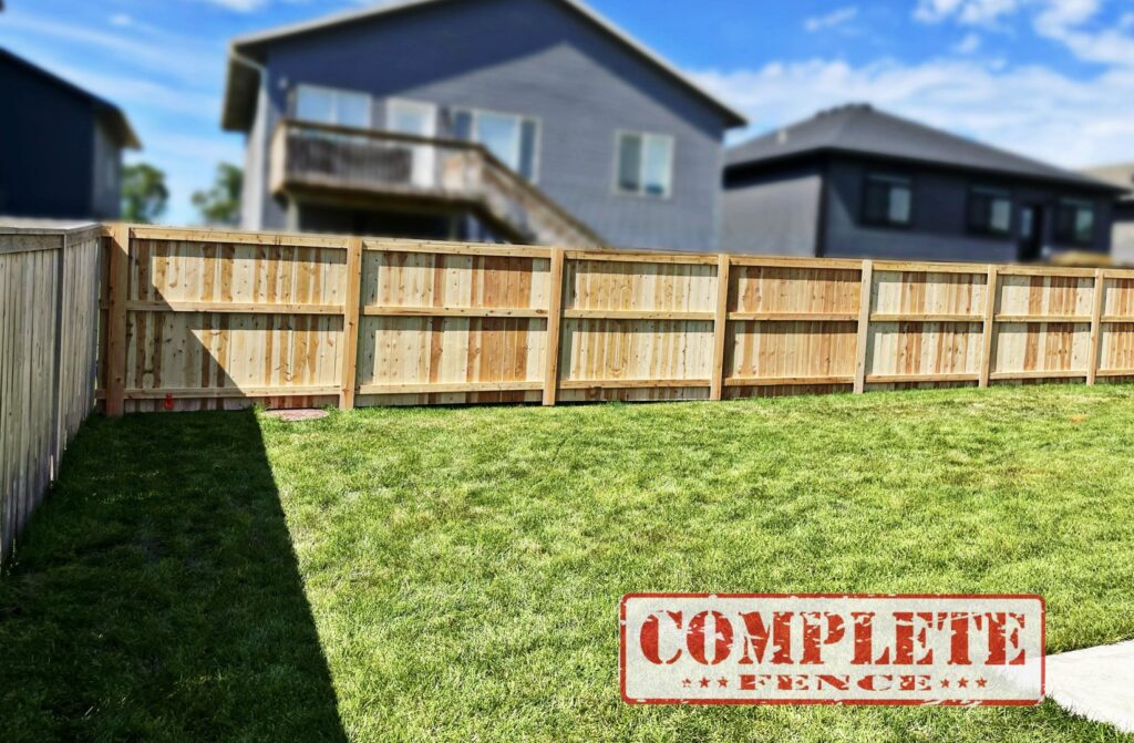 A newly installed wooden privacy fence enclosing a backyard by Complete Fence, LLC in West Chicago, IL