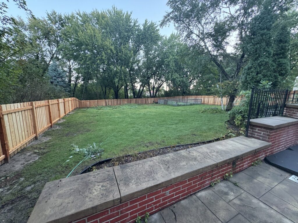 A newly installed wooden privacy fence surrounding a backyard, completed by Mauer Company in Little Canada, MN.