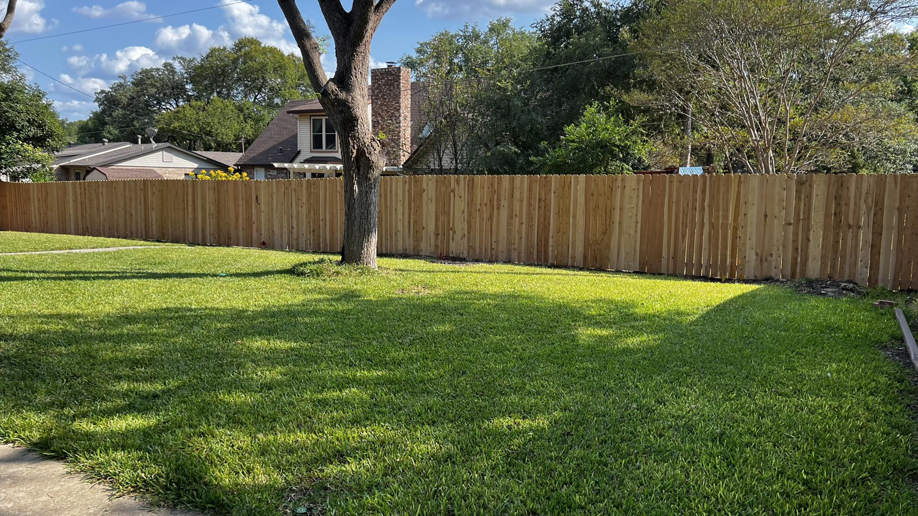 A newly installed wooden privacy fence in a residential backyard by Precision Fences and Decks in San Antonio, TX.
