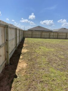 A newly installed wooden privacy fence in a residential backyard by Superior Fence & Rail of North Shore in Gulfport, MS.