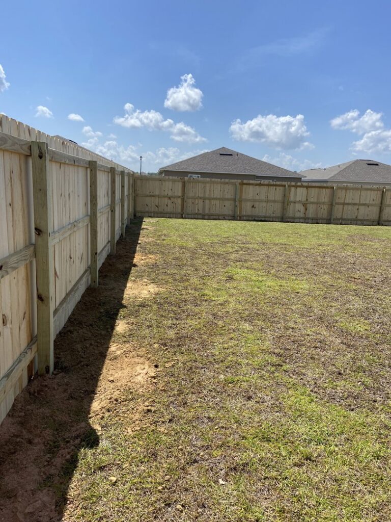 A newly installed wooden privacy fence in a residential backyard by Superior Fence & Rail of North Shore in Gulfport, MS.