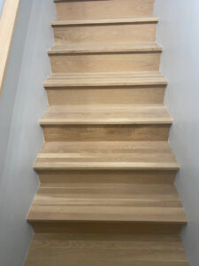 Newly installed light wooden stairs showcasing quality craftsmanship by Peach Design Inc. in Atlanta, GA.