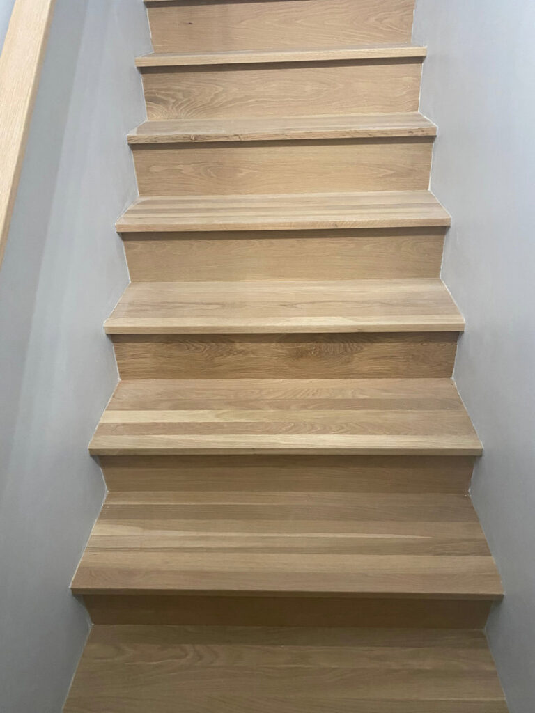 Newly installed light wooden stairs showcasing quality craftsmanship by Peach Design Inc. in Atlanta, GA.