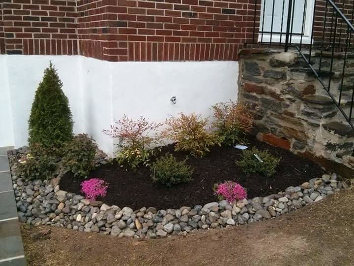 A newly planted garden bed with decorative rocks and fresh mulch by John's Lawn Care Service's in Saint Petersburg, FL