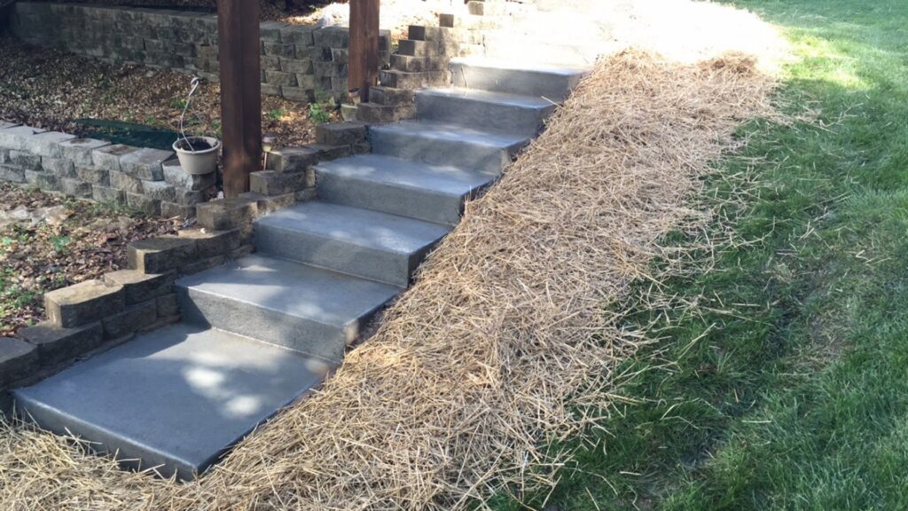 A newly seeded lawn with straw for erosion control and growth, installed by Creamer Construction LLC in Saint Peters, MO.