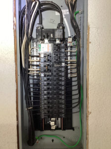 A newly wired electrical panel with circuit breakers and organized wiring by Electrician Near Me in Broken Arrow, OK.