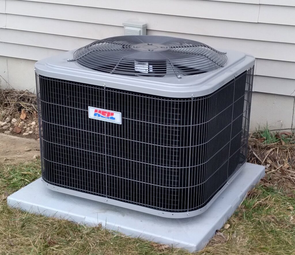 An NHE outdoor air conditioning unit professionally installed next to a home by Kerley Heating & Cooling in Rock City, IL