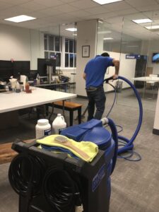 A professional using carpet cleaning equipment and supplies to clean an office carpet for Dalia's Carpet Cleaning in San Francisco, CA.