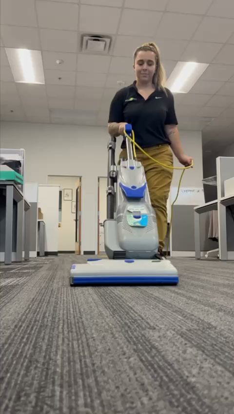 A cleaning technician performing professional carpet cleaning in an office space by All Ways Organic Citrus Carpet & Upholstery Cleaning in Wilmington, NC.