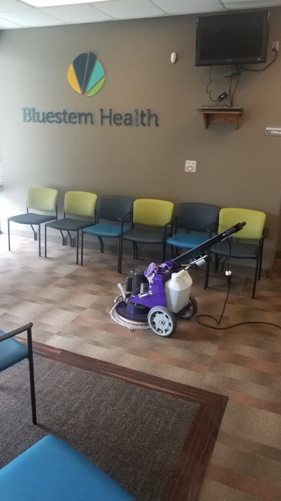 A floor buffer cleaning patterned office carpet in a waiting room at Bluestem Health by Royal Carpet & Upholstery Cleaning in Lincoln, NE.